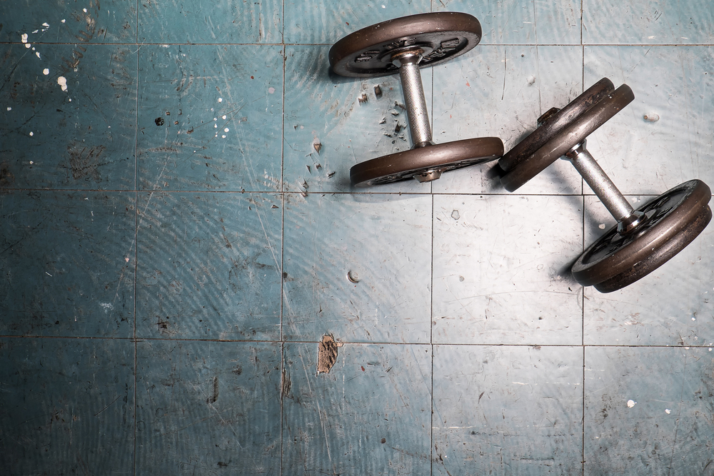 två hantlar som ligger på gymgolvet för att man ska veta hur tungt man ska träna