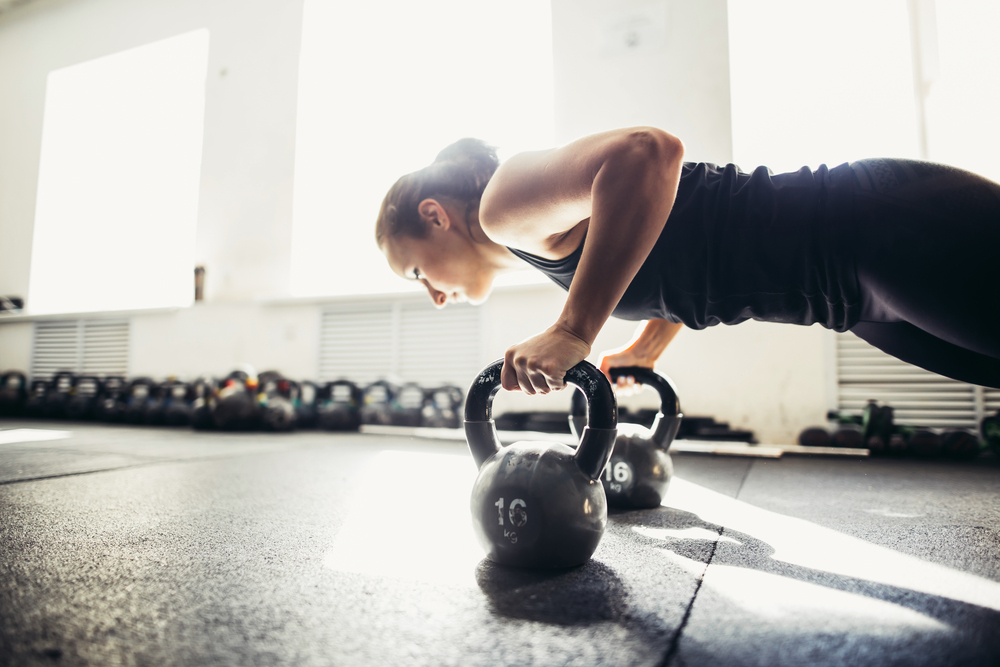 en tjej som vet hur tungt hon ska träna med kettlebells på ett gym