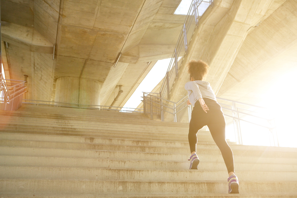 en kvinna som är motiverad och springer upp för långa trappor